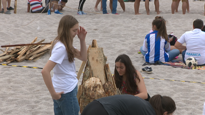 Un grupo de rapazas facendo a cacharela de San Xoán na praia de Riazor