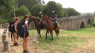 Garda Civil a cabalo informando a peregrinos no camiño Portugués