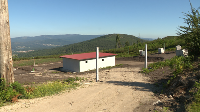 O almacén está por riba das casas rodeado de monte sen limpar