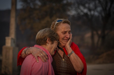 Dúas veciñas da Veiga da Cascallá (Rubiá) choran ao ver os danos que os lumes causaron ás vivendas. | EFE/Brais Lorenzo