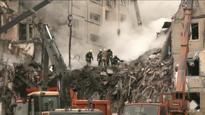 Os bombeiros buscan ás vítimas entre os restos do edificio atacado en Dnipró (Ucraína)
