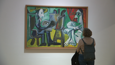 Unha muller contempla un dos cadros de Picasso