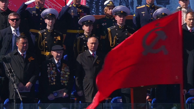 A bandeira soviética pasa ante a tribuna durante o desfile do Día da Vitoria