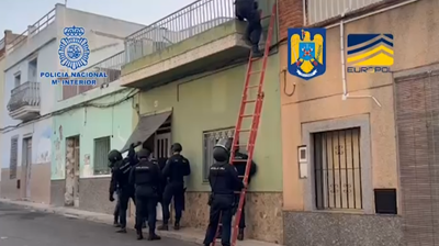 Policía Nacional española e Policía Nacional romanesa entrando nun dos edificios onde se levaba a cabo a actividade (EFE)