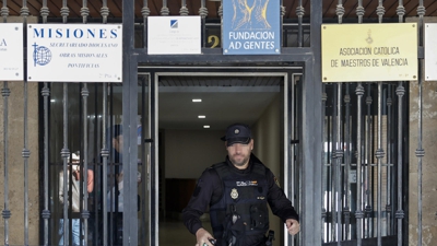 Un axente da Policía Nacional saíndo do edificio onde se investigaban as causas da morte do cóengo emérito da Catedral de Valencia EFE/Biel Aliño