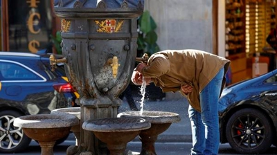 Un home bebe na fonte das Canaletas, nas Ramblas de Barcelona (EFE/Toni Albir)