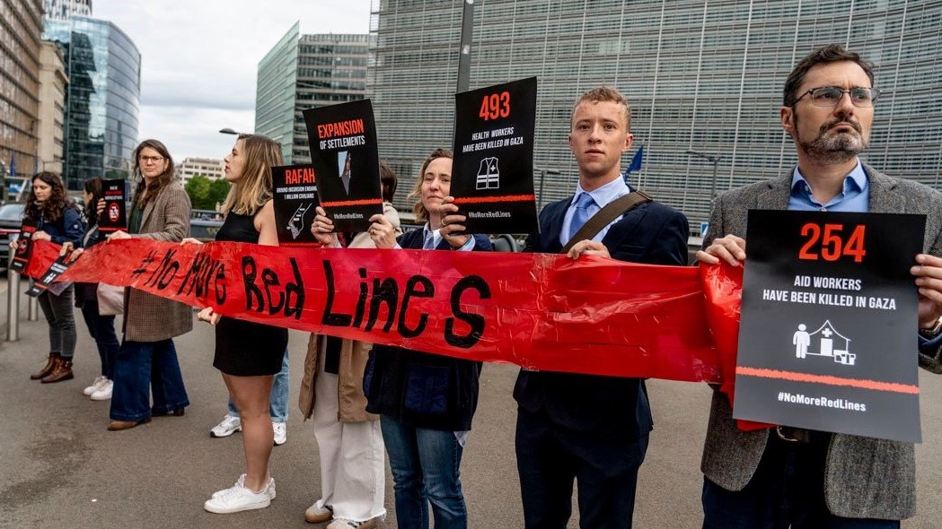 Representantes de organizacións humanitarias colocaron este luns unha cinta vermella fronte ás institucións comunitarias en Bruxelas coincidindo co Consello de Ministros de Exteriores da Unión Europea (Foto: Intermon Oxfam)