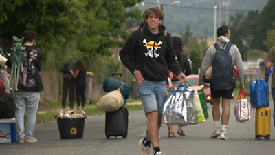 Centos de festivaleiros cargados coas súas cousas para durmir na zona de acampada