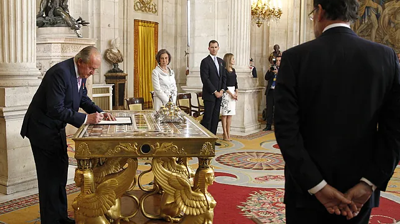 O rei Xoán Carlos I asina a súa abdicación en zuño de 2014