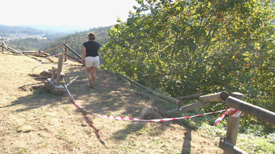 A presidenta da comunidade de montes revisa os danos no miradoiro